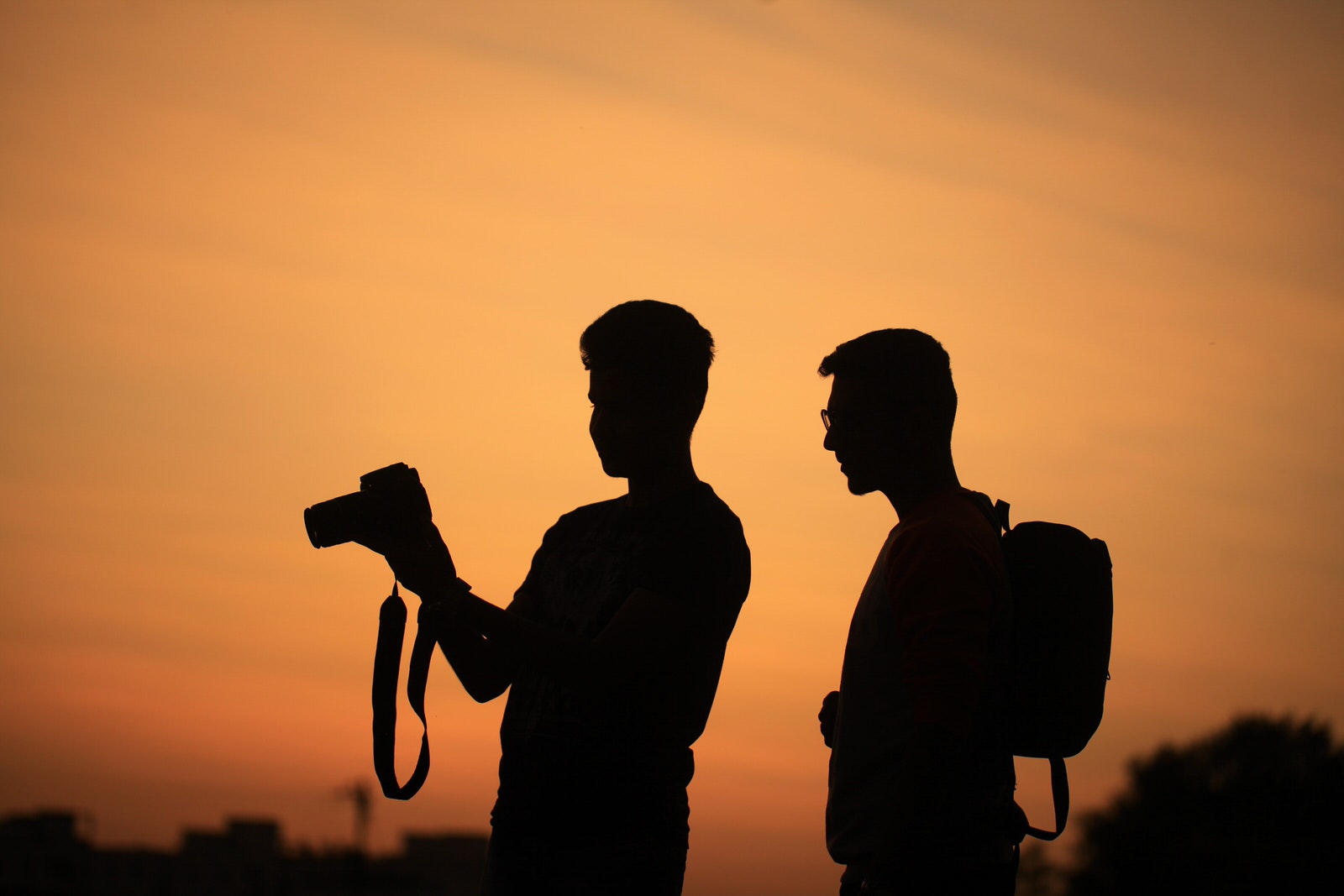 Silhouetted men looking at the back of a camera screen