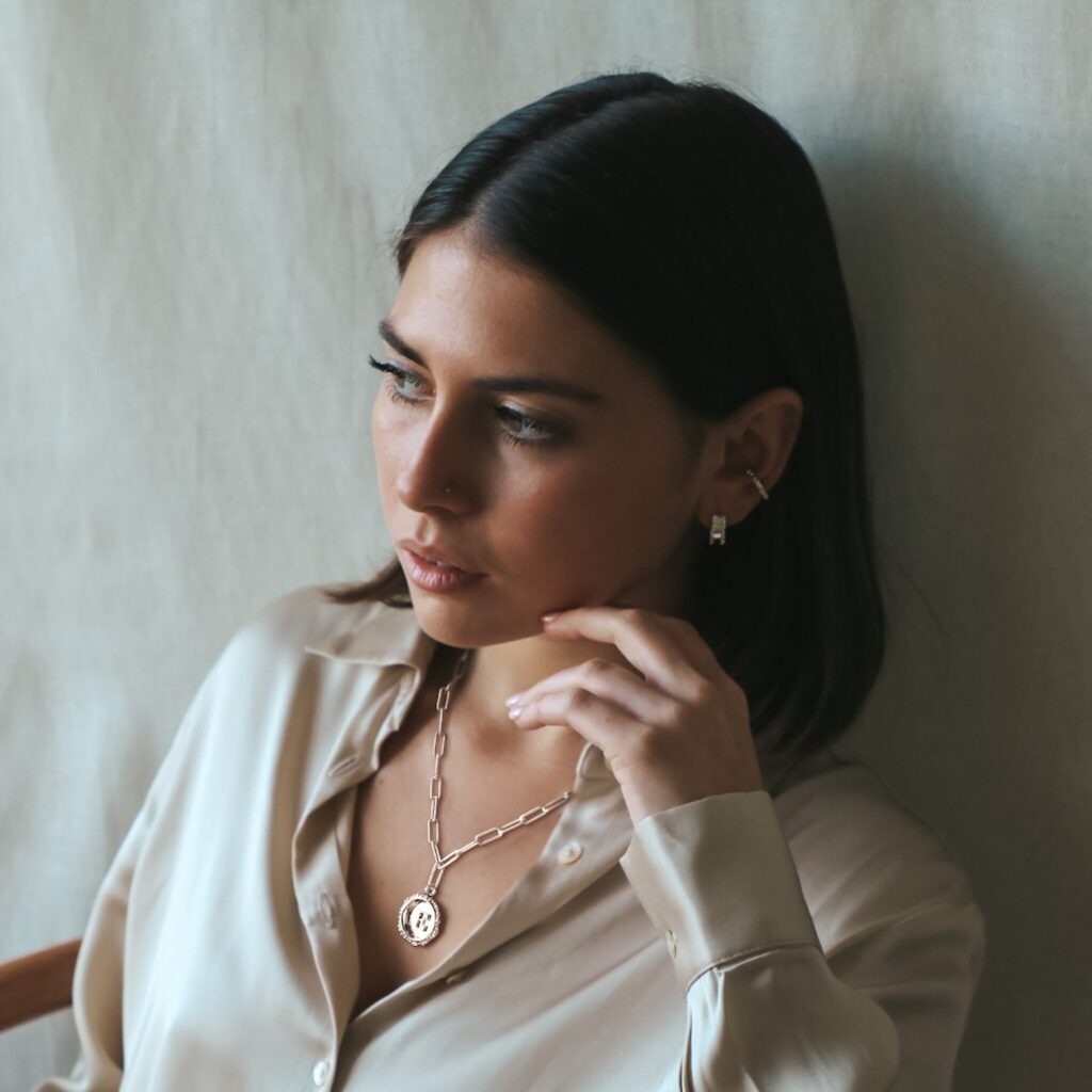 Stylish woman wearing Militza Ortiz beskpoke initial letter silver pendant necklace. 